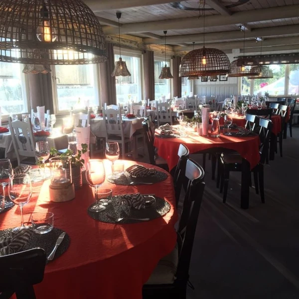 Lövåsgårdens hotell, dukad matsal med röda dukar och stora fönster